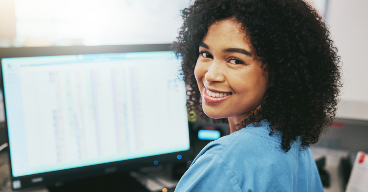 Happy healthcare professional smiling while working on computer 